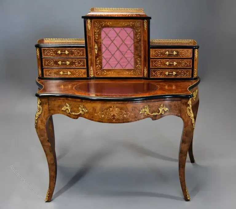 “Restored antique desk with carved wood and pink fabric panel—expert craftsmanship by First Class MasterCraft”