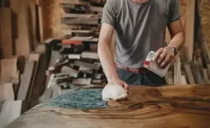 Craftsman repairing striping down and sanding wood surface—First Class MasterCraft furniture restoration