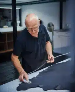 craftsman working on table measuring leather