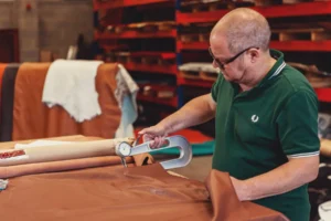 First Class MasterCraft team member cutting fabric at upholstery bench – Fort Lee Distribution Hub