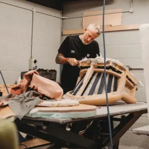 “Upholsterer working on chair at bench – hands-on restoration by First Class MasterCraft Fort Lee”