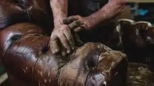 team members on action repairing leather arm on chair